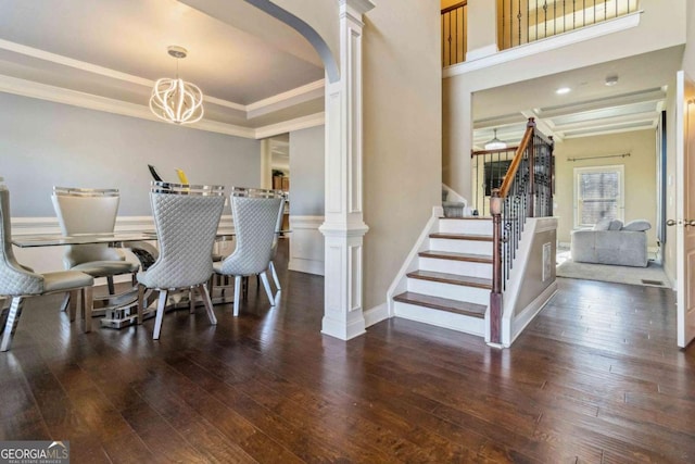 dining space with a tray ceiling, crown molding, dark wood-type flooring, and decorative columns