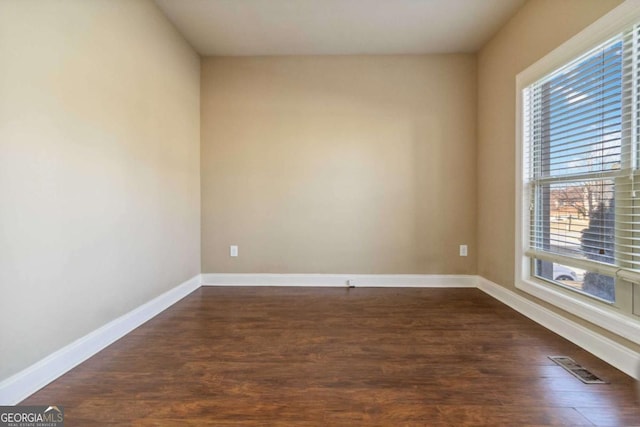 spare room with dark hardwood / wood-style floors