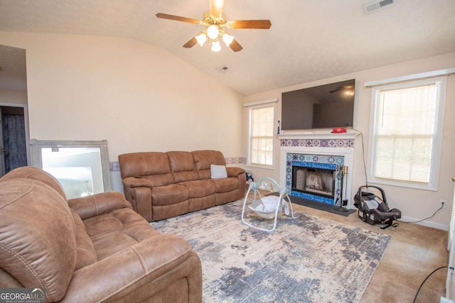 carpeted living room featuring ceiling fan, a fireplace, and lofted ceiling