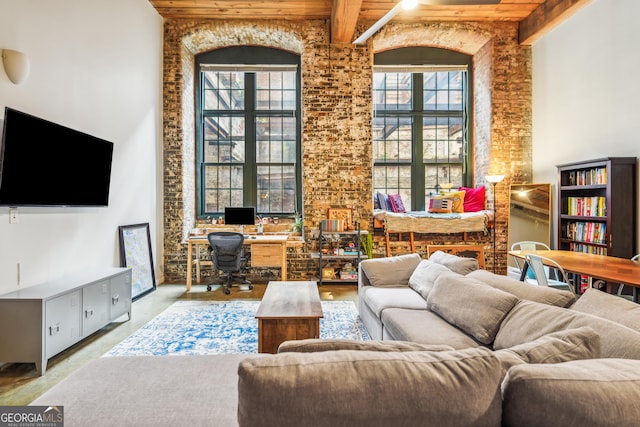 living room featuring beamed ceiling, plenty of natural light, wood ceiling, and a towering ceiling