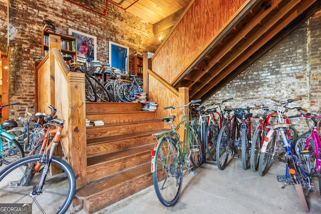 interior space with brick wall, concrete floors, and wood walls