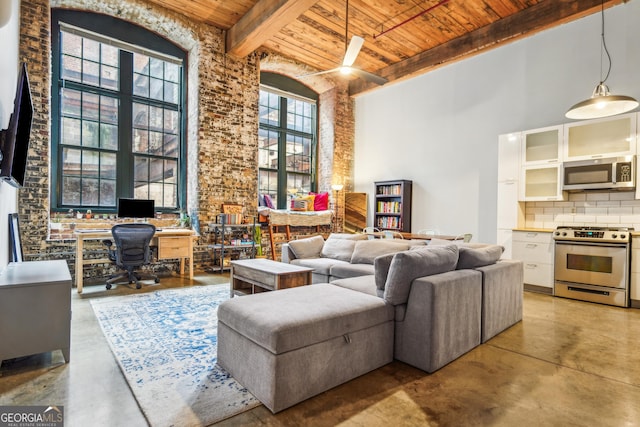 living room with beamed ceiling, wooden ceiling, and a high ceiling