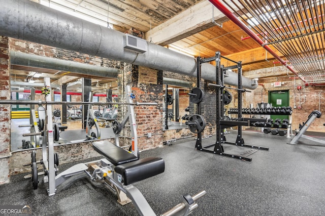 workout area featuring brick wall