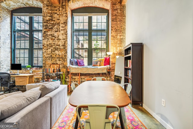 sitting room featuring plenty of natural light and brick wall