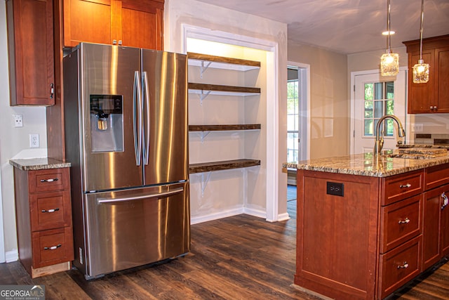 kitchen with stainless steel refrigerator with ice dispenser, light stone counters, sink, dark hardwood / wood-style floors, and hanging light fixtures