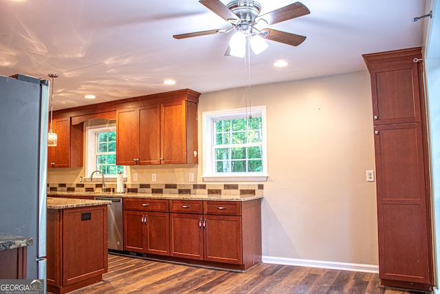 kitchen with light stone counters, dark wood-type flooring, and appliances with stainless steel finishes