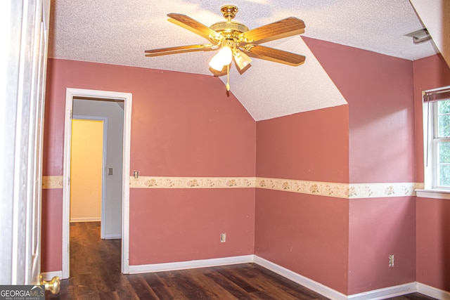 empty room featuring vaulted ceiling, ceiling fan, dark hardwood / wood-style flooring, and a textured ceiling