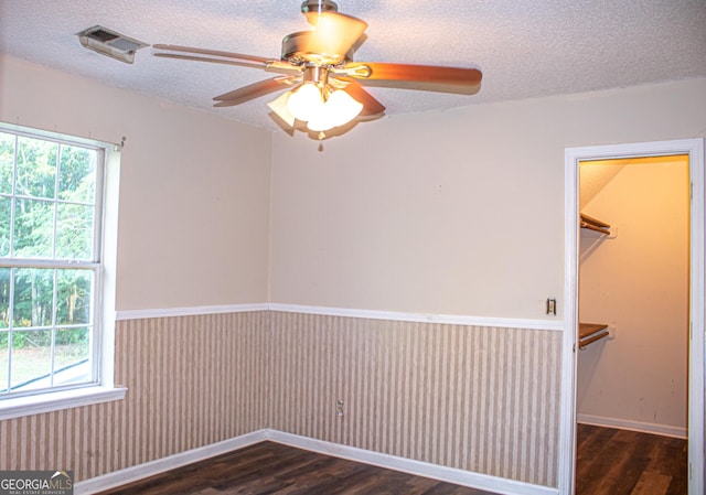 spare room featuring ceiling fan, dark hardwood / wood-style floors, and a textured ceiling