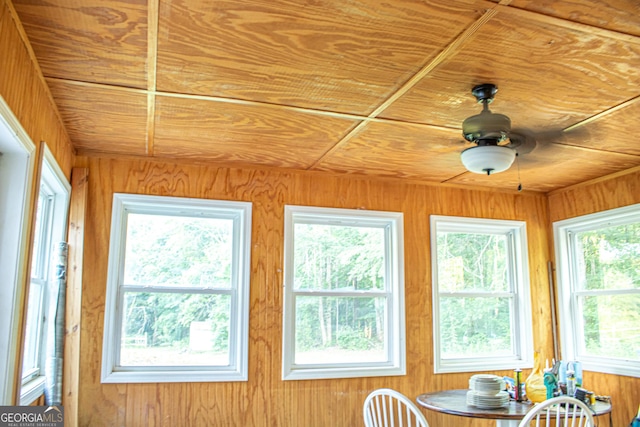 unfurnished sunroom featuring ceiling fan