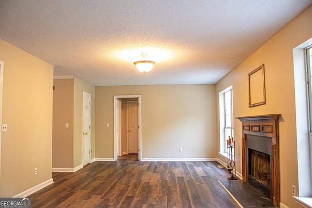 unfurnished living room with dark hardwood / wood-style flooring and a textured ceiling