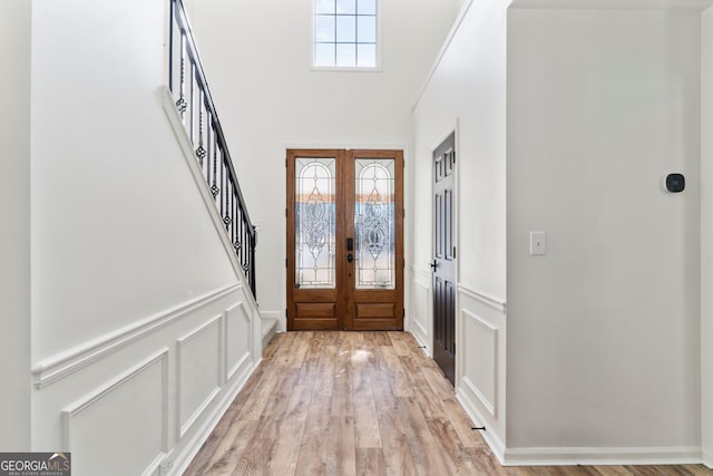 foyer featuring french doors, light hardwood / wood-style flooring, and plenty of natural light