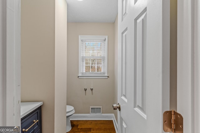 bathroom featuring hardwood / wood-style floors, vanity, a textured ceiling, and toilet