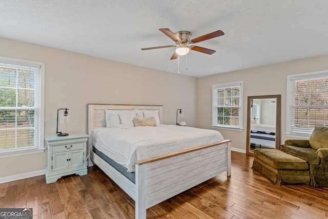 bedroom with multiple windows, ceiling fan, and hardwood / wood-style floors