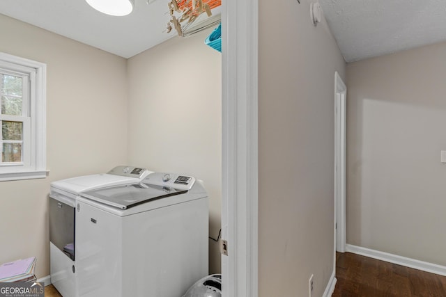 laundry area with dark wood-type flooring and washer and dryer