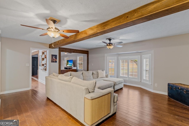 living room with beamed ceiling, a textured ceiling, hardwood / wood-style flooring, and ceiling fan