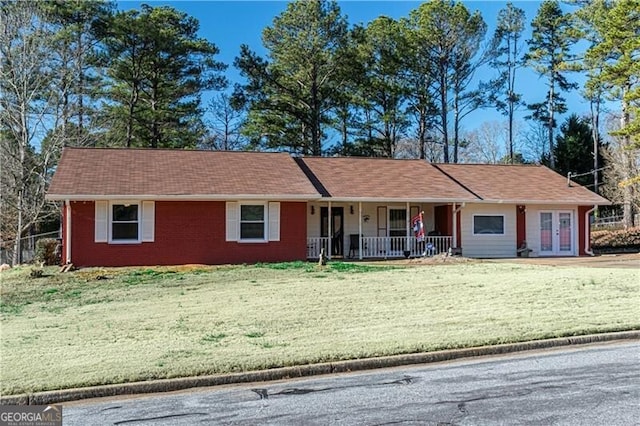 ranch-style house featuring covered porch, french doors, and a front lawn