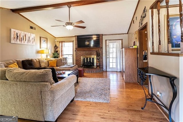 living room featuring hardwood / wood-style flooring, lofted ceiling with beams, ceiling fan, and a fireplace