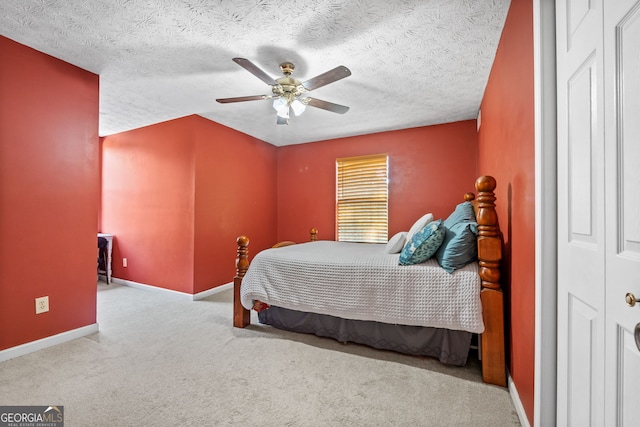 bedroom featuring ceiling fan, a closet, light carpet, and a textured ceiling