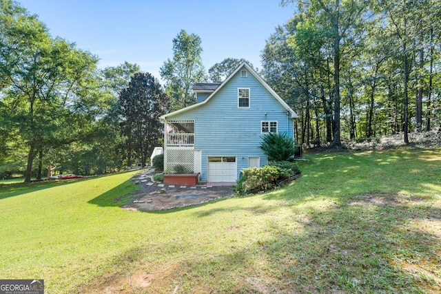 rear view of property featuring a lawn and a garage