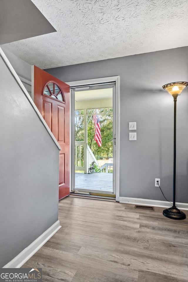 entryway featuring a textured ceiling and hardwood / wood-style flooring