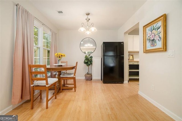 dining room featuring a chandelier and light wood-type flooring