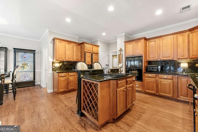 kitchen featuring decorative backsplash, black double oven, light wood-type flooring, dark stone countertops, and a kitchen island