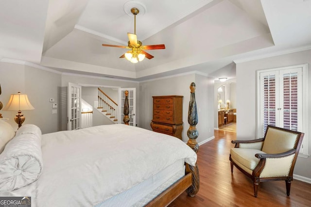 bedroom featuring ceiling fan, french doors, crown molding, and a tray ceiling