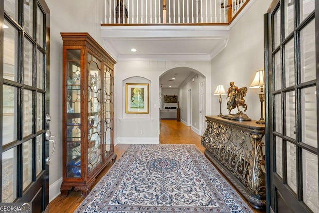 foyer entrance featuring light hardwood / wood-style flooring, ornamental molding, and french doors