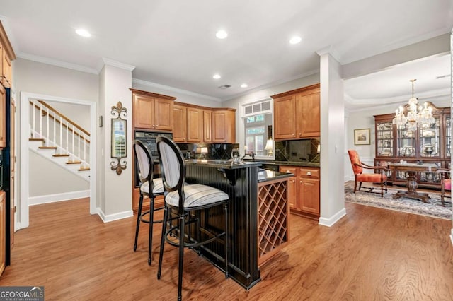 kitchen with crown molding, backsplash, a breakfast bar, and a center island