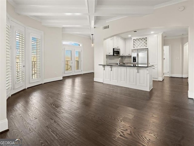 unfurnished living room with crown molding, dark hardwood / wood-style floors, beamed ceiling, and french doors