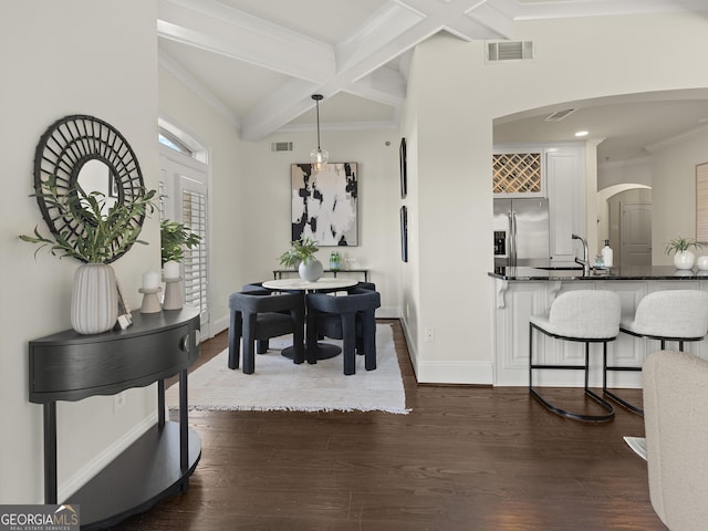 dining area with sink, coffered ceiling, crown molding, dark wood-type flooring, and beam ceiling