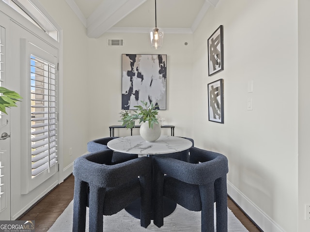 dining space featuring dark hardwood / wood-style flooring, beam ceiling, and ornamental molding