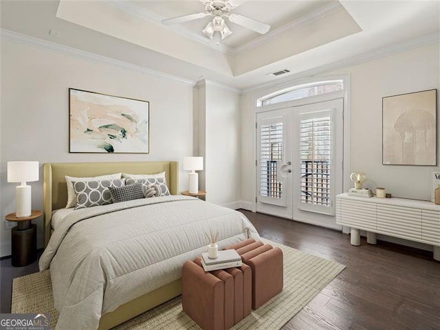 bedroom with crown molding, access to exterior, a tray ceiling, and hardwood / wood-style floors