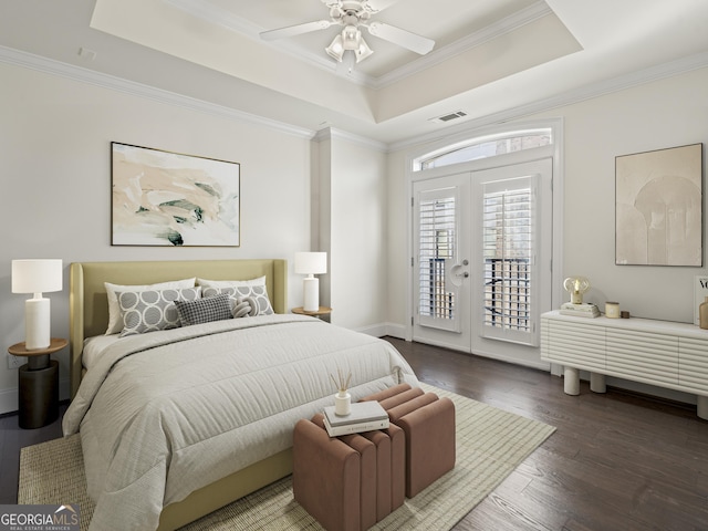 bedroom with ornamental molding, access to outside, a raised ceiling, dark wood-type flooring, and french doors