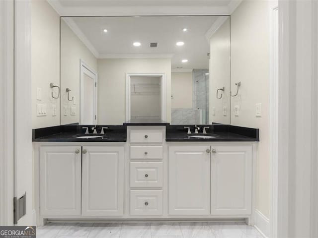 bathroom with vanity, crown molding, and a shower with door