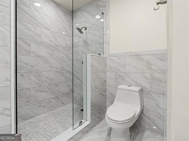 bathroom with toilet and a tile shower