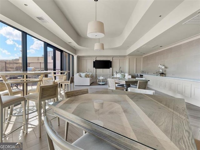 dining space with a raised ceiling