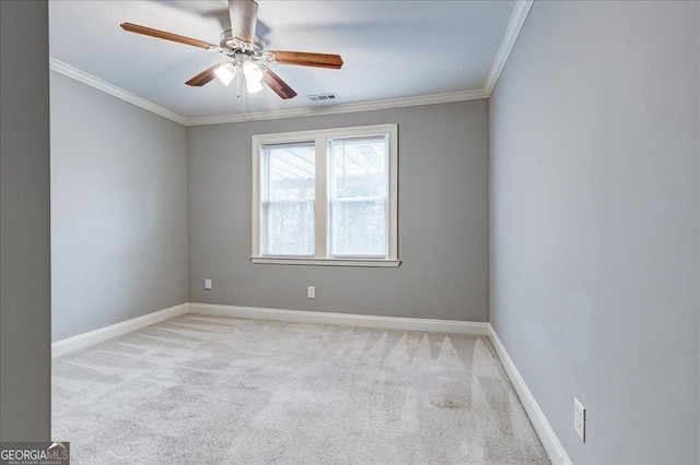 carpeted empty room featuring ceiling fan and crown molding