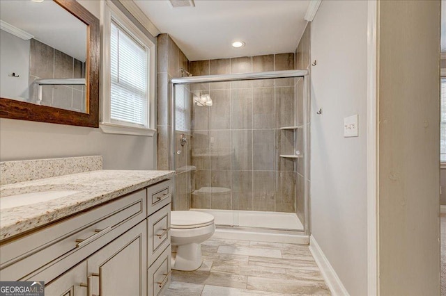 bathroom with walk in shower, crown molding, vanity, and toilet