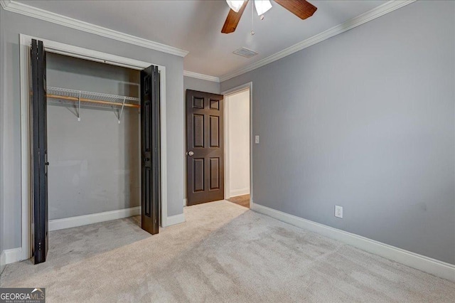 unfurnished bedroom with ceiling fan, light colored carpet, crown molding, and a closet