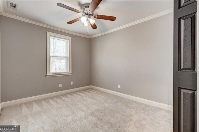 carpeted spare room featuring ceiling fan and crown molding