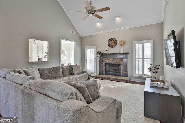 living room featuring ceiling fan, high vaulted ceiling, hardwood / wood-style floors, a fireplace, and ornamental molding