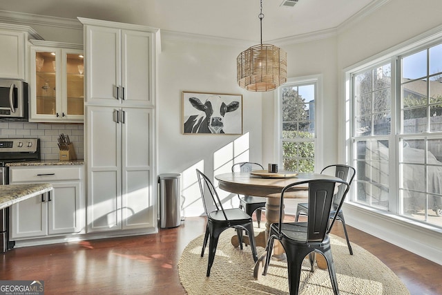 dining room with dark wood-type flooring and crown molding