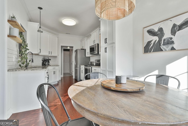 dining room featuring ornamental molding and sink