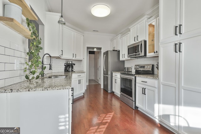 kitchen with decorative light fixtures, stainless steel appliances, white cabinetry, and tasteful backsplash