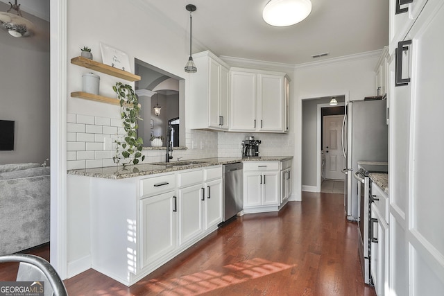 kitchen with white cabinets, sink, hanging light fixtures, decorative backsplash, and stainless steel appliances