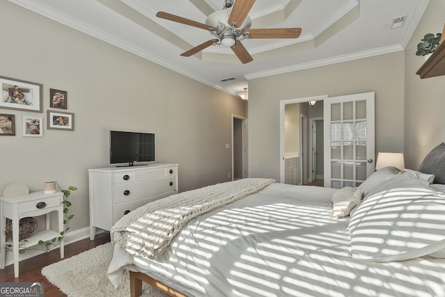 bedroom with ensuite bath, ceiling fan, ornamental molding, a tray ceiling, and dark hardwood / wood-style flooring