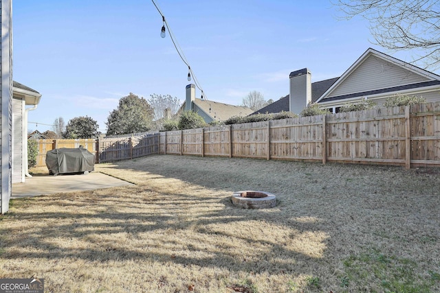 view of yard featuring a patio and an outdoor fire pit