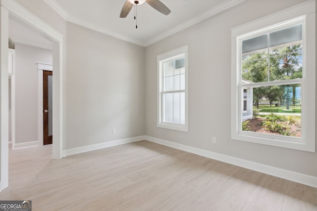 spare room featuring ornamental molding, plenty of natural light, and light hardwood / wood-style floors