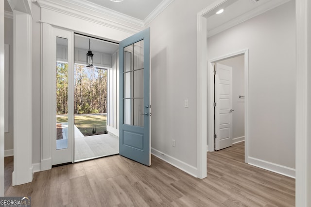 foyer entrance with crown molding, wood finished floors, and baseboards